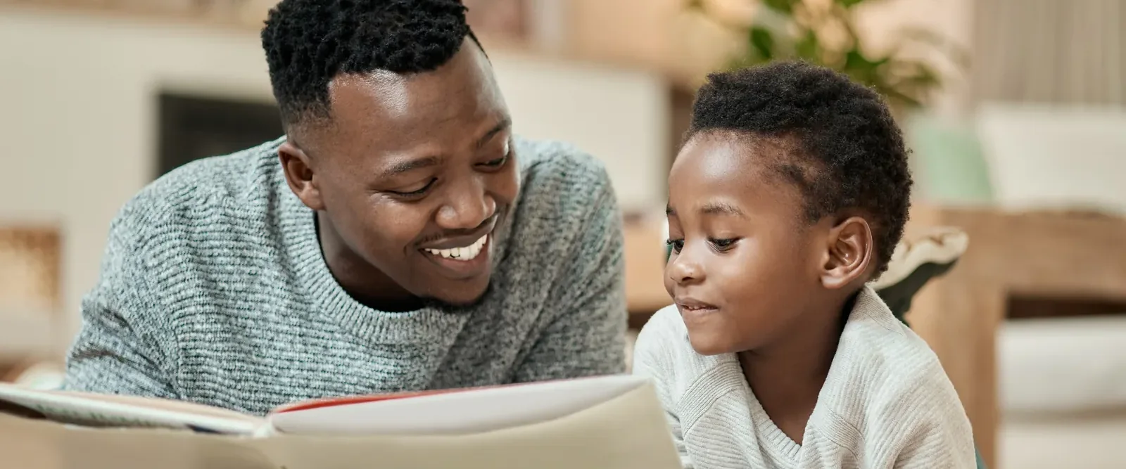 A father and his young son reading a picture book together at home