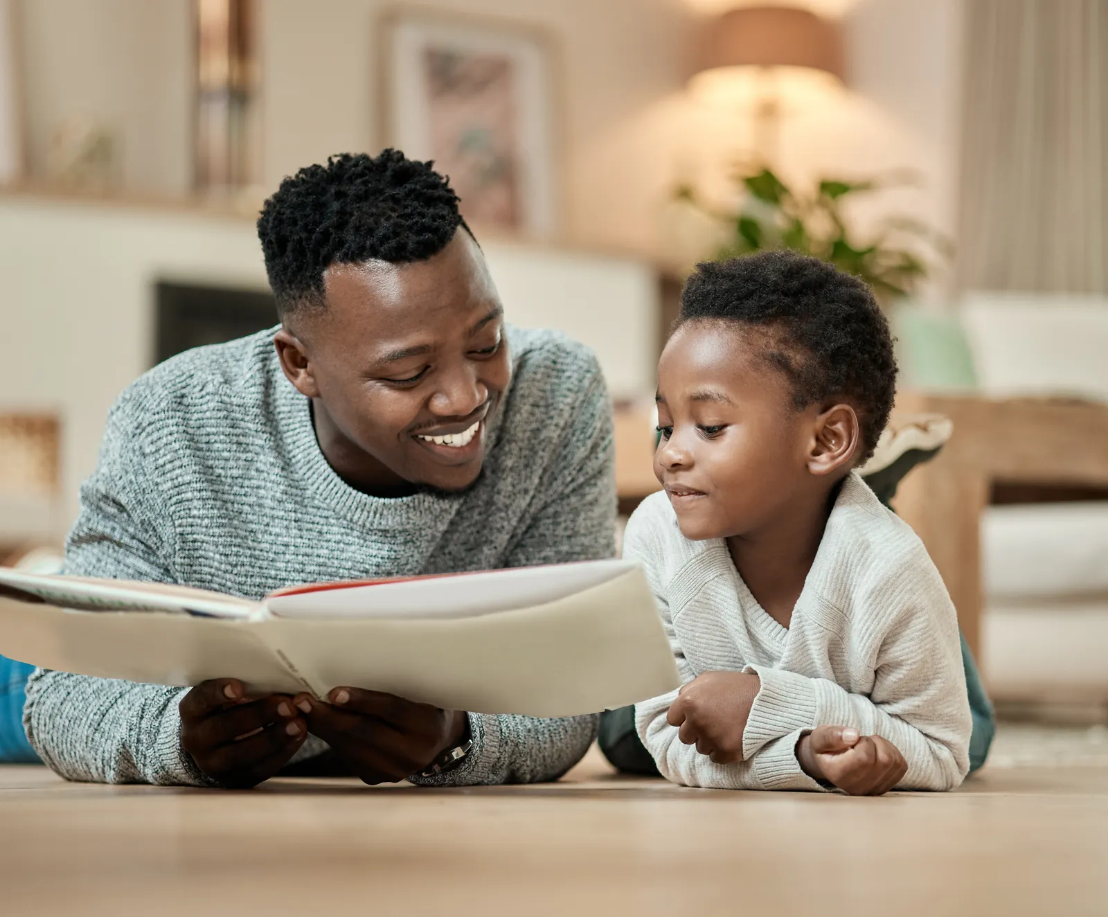 A father and his young son reading a picture book together at home