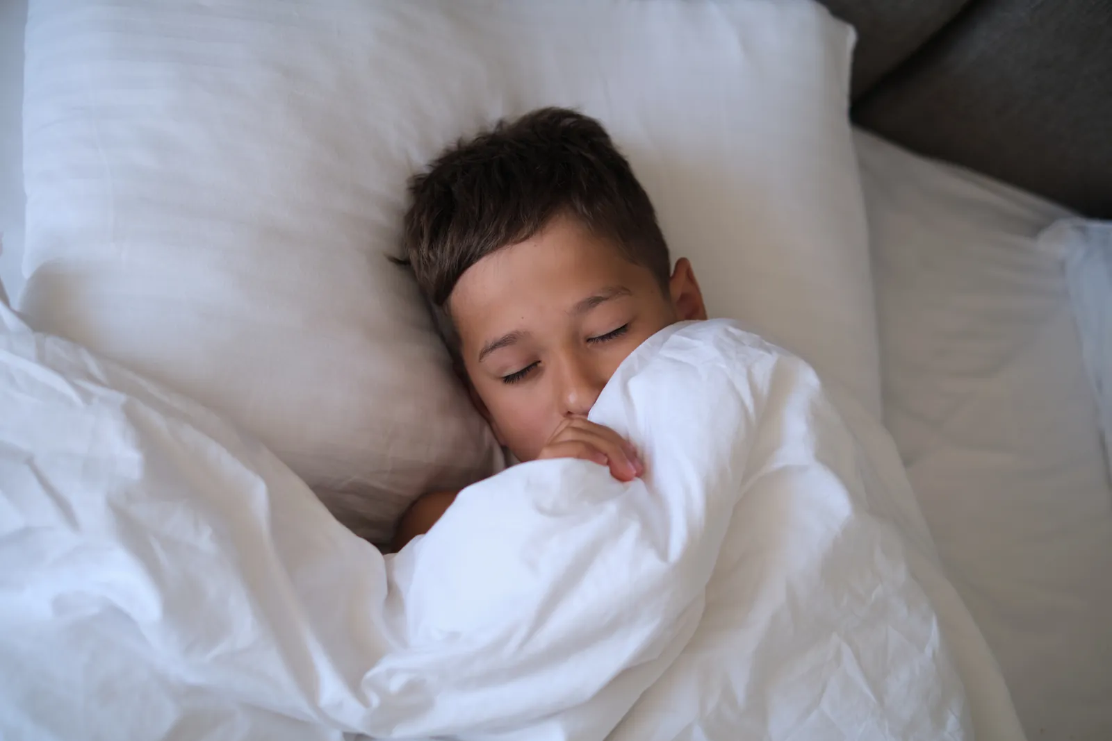 A young boy asleep in bed